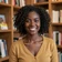 Black woman smiling in a bookstore, a member sharing why she finds military men attractive